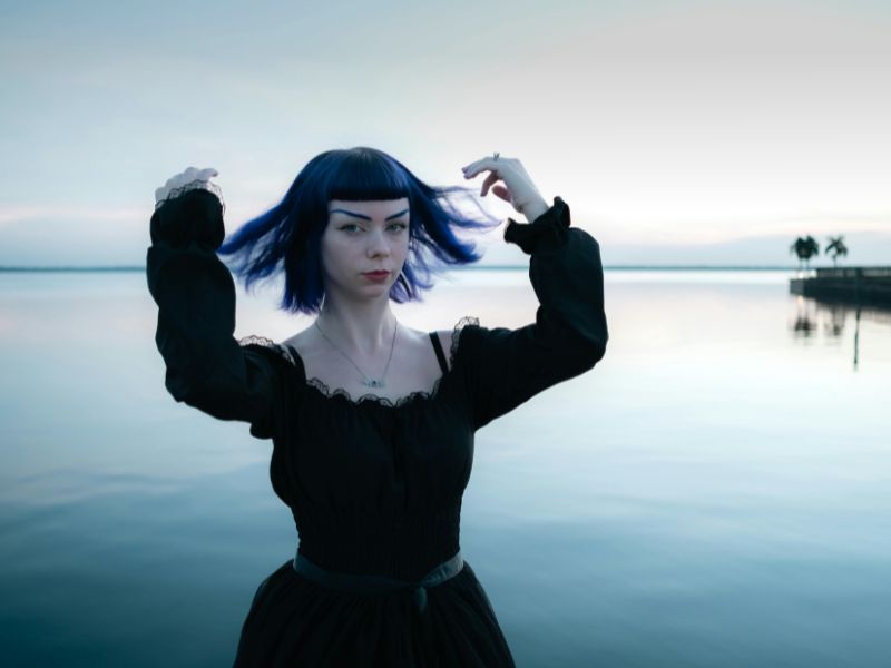 A woman with colored hair beside in ocean