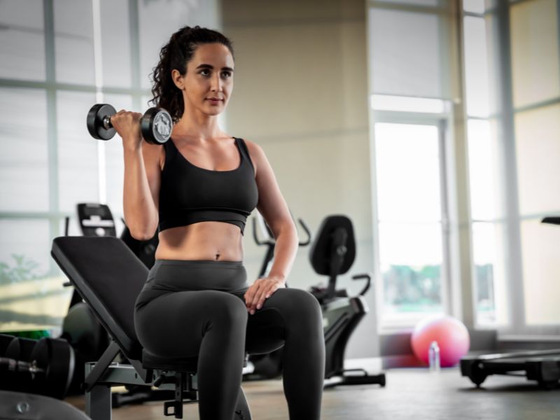 A woman lifting the barbel in the gym