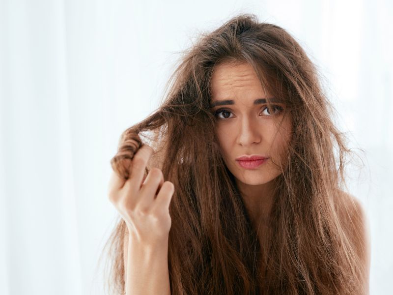 A woman holding her damage hair
