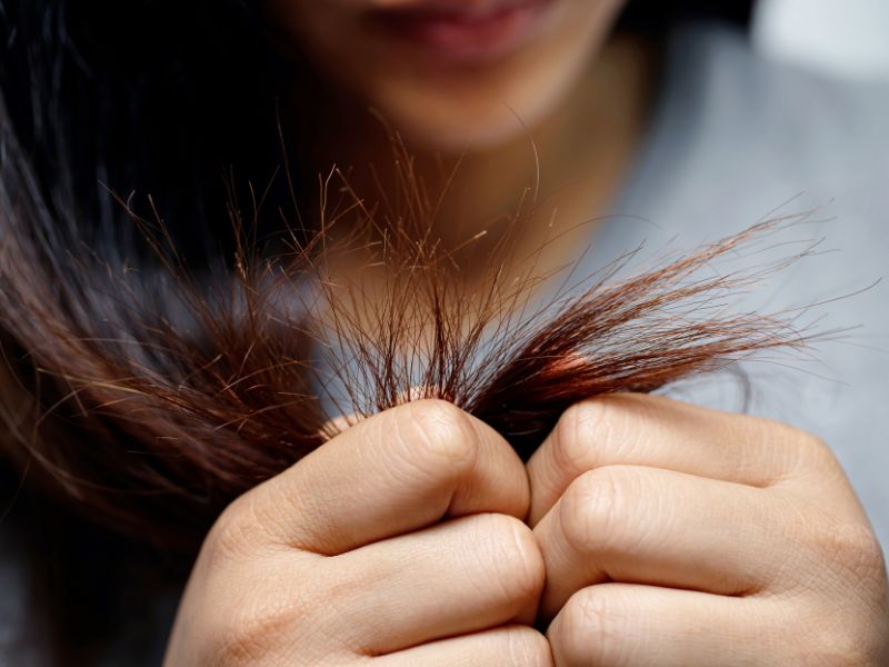 A woman looking split ends on her hair